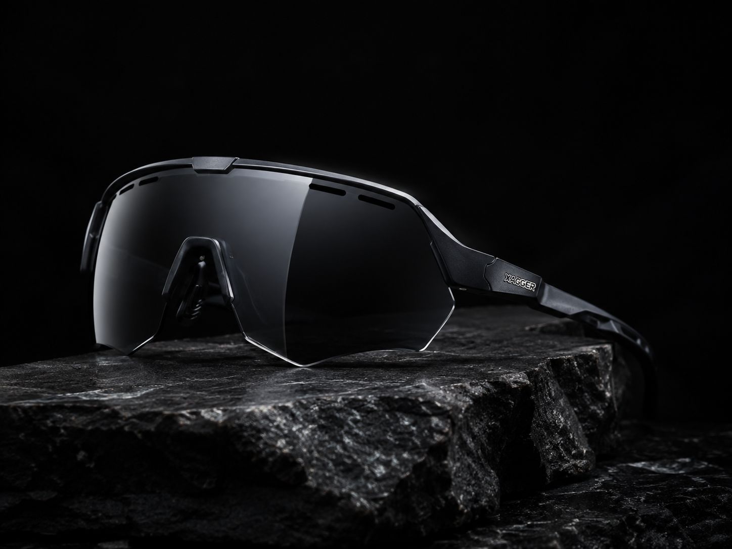 A XAGGER frame resting on dark stone, low-key studio